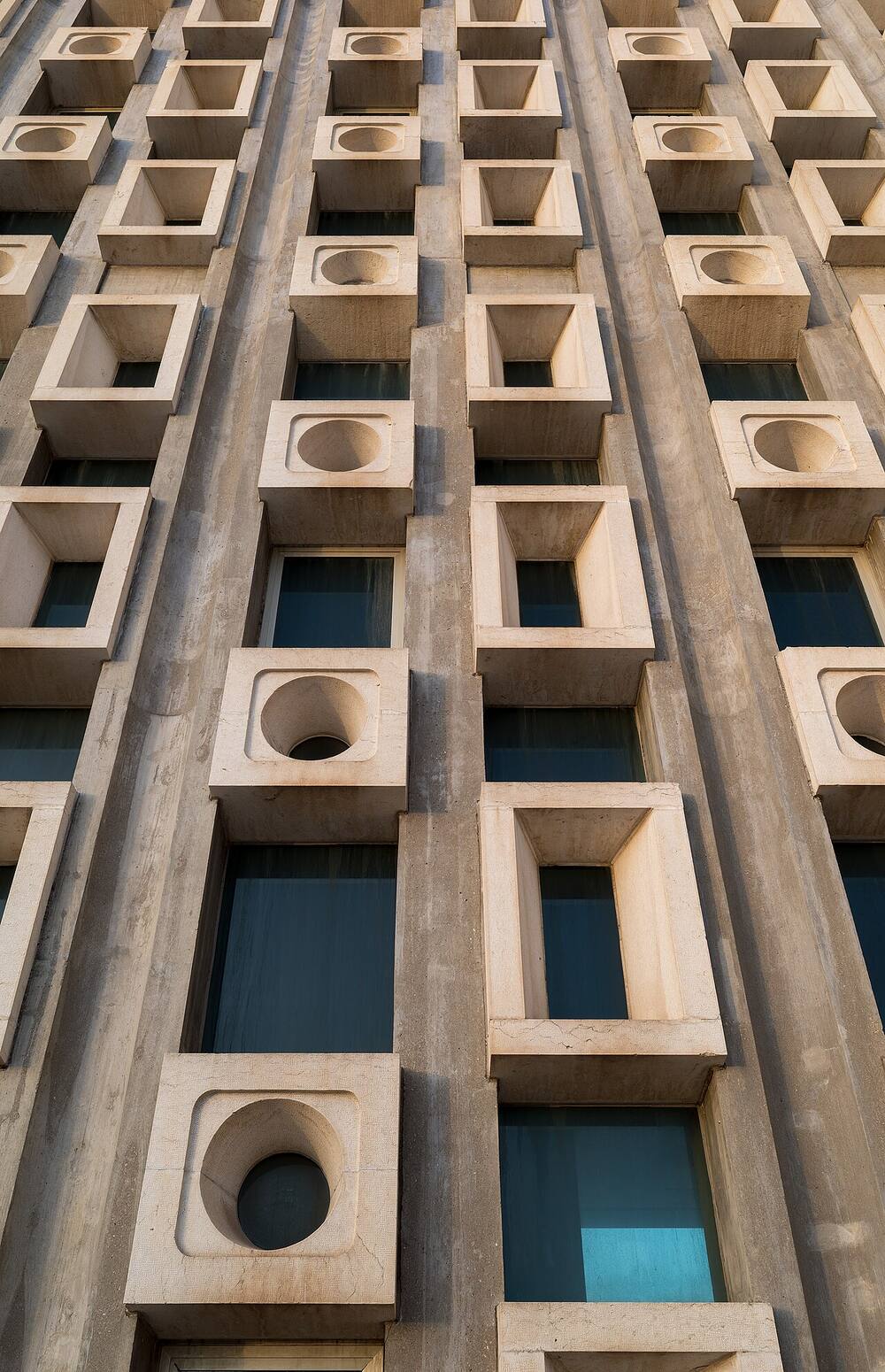 Carved stone facade with deep-set square windows and round medallions